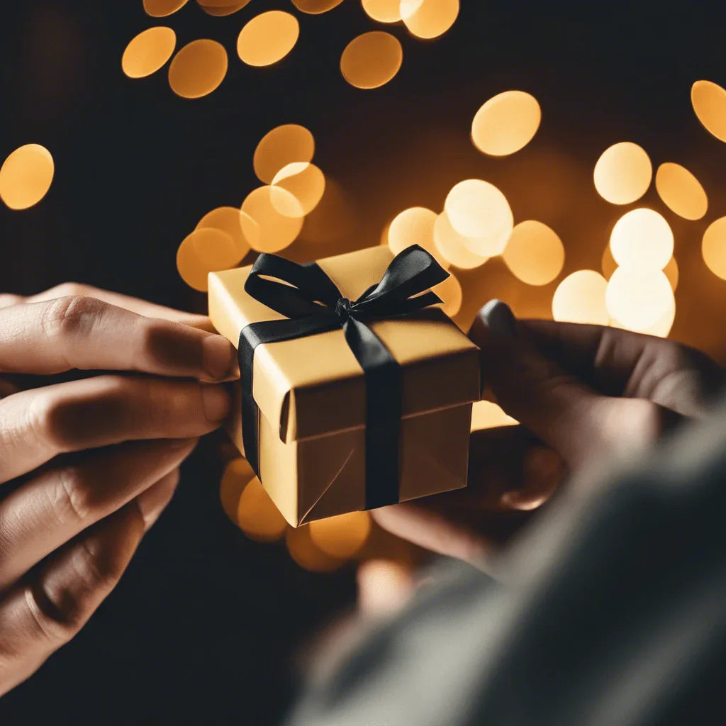 Scambio di piccolo regalo regalo dorato con nastro nero su sfondo luci sfocate