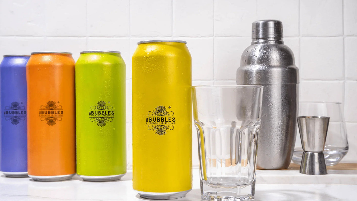 Lattine colorate Mr Bubbles cocktail artigianali con bicchieri e shaker in cucina bianca